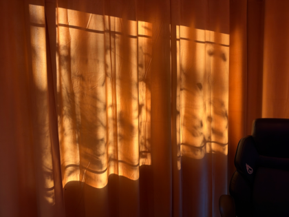 a curtain with light and shadows of forms behind it
